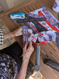 Astley View residents enjoy a relaxing afternoon painting pebbles, contributing to a VE Day-themed garden tribute.