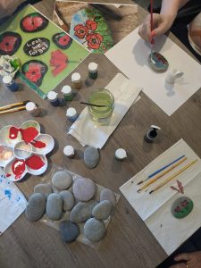 Astley View residents enjoy a relaxing afternoon painting pebbles, contributing to a VE Day-themed garden tribute.